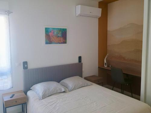 une chambre avec un lit et un tableau au mur dans l'établissement AYAPI - Appartement neuf 3 étoiles avec terrasse et jardin - bord de plage, à Marseillan