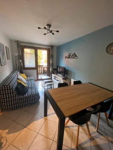 un salon avec une table et un canapé dans l'établissement Appartement tout confort centre, à Arâches-la-Frasse