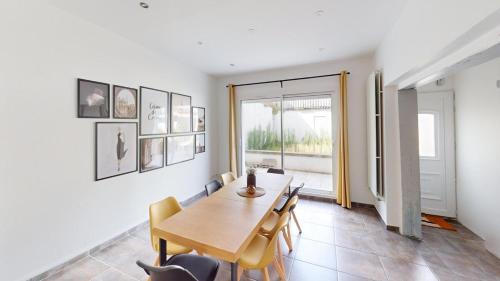 une salle à manger avec une table et des chaises en bois dans l'établissement Maison T7 - Rue des briquetiers, au Havre