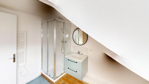 une salle de bain blanche avec un lavabo et un miroir dans l'établissement Maison T7 - Rue des briquetiers, au Havre