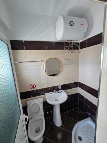 a small bathroom with a toilet and a sink at Elio's Rooms in Ksamil