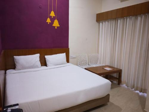 a bedroom with a large white bed and a table at Rockwood Resort in Pāonta Sāhib