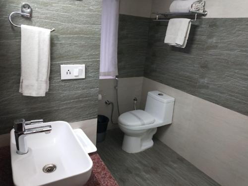 a bathroom with a toilet and a sink and towels at Rockwood Resort in Pāonta Sāhib