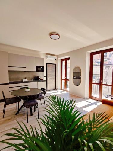 a living room with a table and a kitchen at La Morra Apartments in La Morra