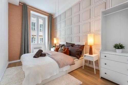 une chambre avec un lit blanc et une fenêtre dans l'établissement 2P architecte Hyper-centre, à Nice