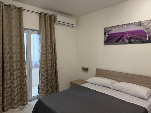 a bedroom with a bed and a large window at Oreto Apartment in Palermo