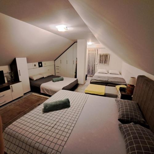 a attic room with three beds in a room at Vikendica Nature park Banja Luka in Banja Luka