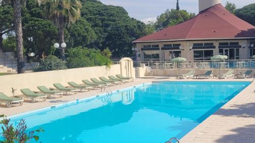 une piscine dans un complexe hôtelier avec des chaises et un bâtiment dans l'établissement La Joya de Villepey, à Saint-Aygulf
