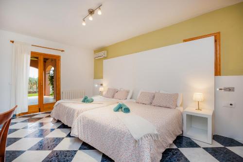 two beds in a bedroom with a checkered floor at Casa Campillos in Llucmajor