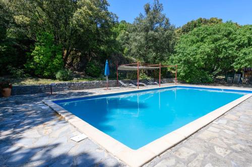 une grande piscine bleue avec un gazebo dans l'établissement Le Sivelou - Gîte 9 personnes, à Saint-Félix-de-Pallières