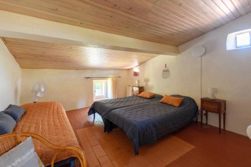 ein Schlafzimmer mit großem Bett und Holzdecke in der Unterkunft Le Sivelou - Gîte 9 personnes in Saint-Félix-de-Pallières