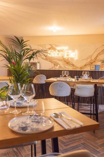 a restaurant with tables and chairs with wine glasses at Maison Gabrielle in Vals-les-Bains