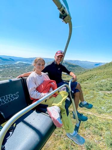a man and a woman riding on a gondola at Hovdestøylen Apartments in Hovden