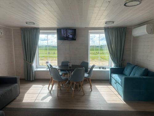 a living room with a table and chairs and a couch at A-Spot - A-formos nameliai ir poilsio sodyba in Roglaičiai I