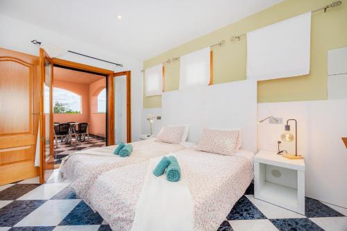 a bedroom with two beds and a checkered floor at Casa Campillos in Llucmajor