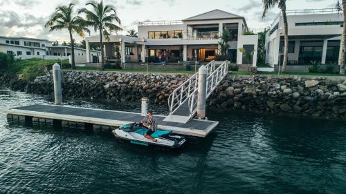 a man on a boat on the water near a house at Trilogy Villas Denarau in Denarau
