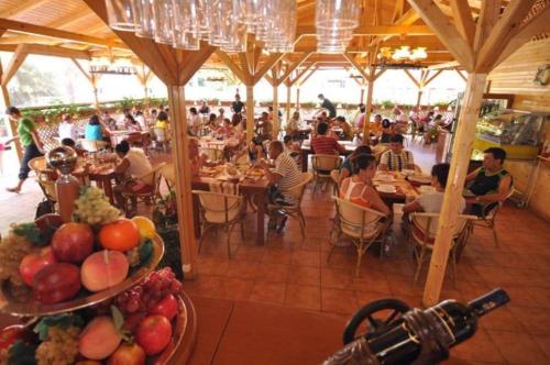 een groep mensen die aan tafels in een restaurant zitten bij Hotel Pinguin in Eforie Nord