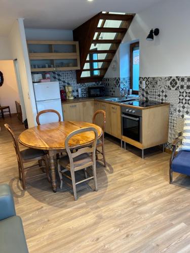 une cuisine avec une table en bois et une salle à manger dans l'établissement Maison Algus, à Cucq