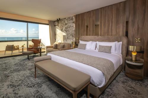 a bedroom with a large bed and a large window at Idou Malabata Beach and SPA in Tangier