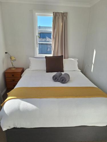 a bedroom with a bed with two towels on it at Oxford Retreat in Martinborough 