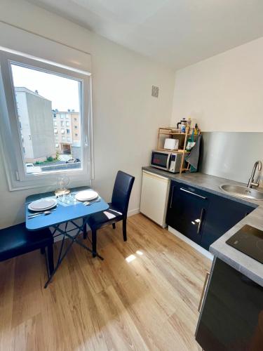 ein kleines Zimmer mit einem Tisch und einer Küche in der Unterkunft L'Hélios - T1 Bis - Bord de Sarthe in Le Mans