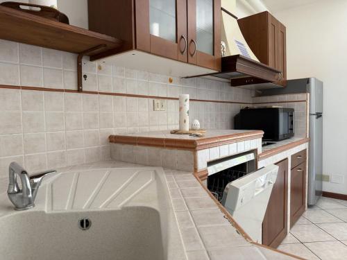 una cocina con fregadero y estufa horno superior en La Casa di Carola - by Host4U, en Imperia