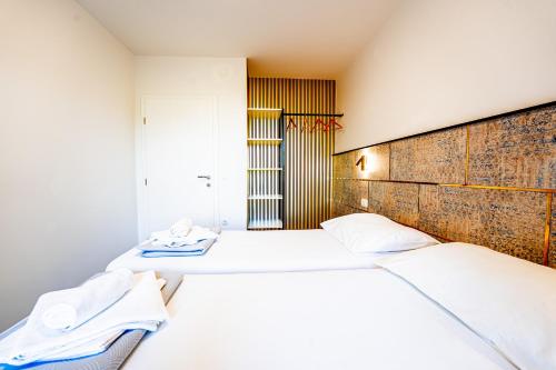 a bedroom with two beds with white sheets at Resort Trcol in Novalja