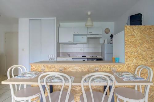 une cuisine avec une table, des chaises et un comptoir dans l'établissement Le Virebent 3 lits parking facile, à Toulouse