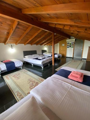 a bedroom with three beds in a room with wooden ceilings at Villa ANATOLIAN in Antalya
