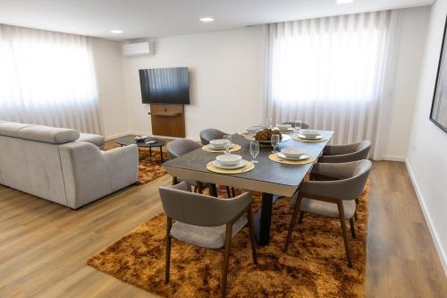a living room with a table and chairs and a couch at Apartmento - Casa dos Meninos in Godim