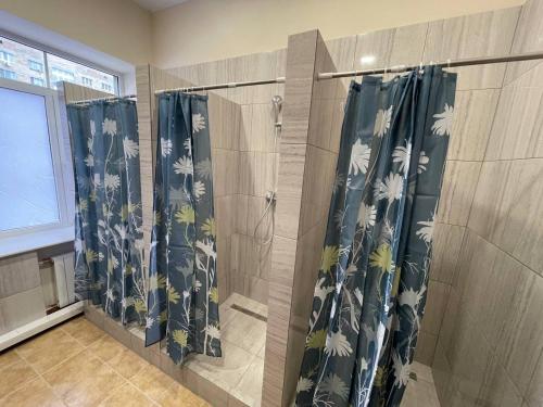 a bathroom with four shower curtains on a wall at uaHOSTEL in Kyiv