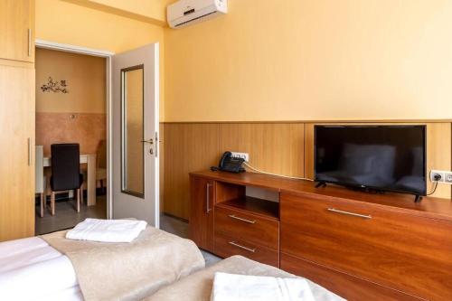 a hotel room with two beds and a flat screen tv at Plaza Hotel Gyula in Gyula