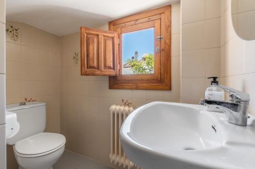 ein Badezimmer mit Waschbecken und Toilette und einem Fenster in der Unterkunft La Era de Alcántara in Cónchar