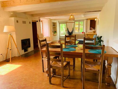 une salle à manger avec une table et des chaises en bois dans l'établissement Maison de charme sur le plateau du Vercors au calme dans un véritable écrin de verdure, à Engins