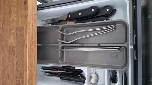 an open refrigerator drawer with utensils in it at Apartment for 6 people CDG and Asterix parc in Survilliers
