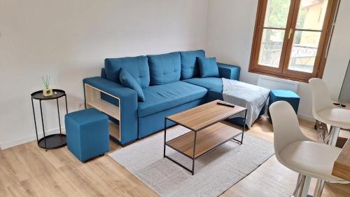 a blue couch in a living room with a table at Apartment for 6 people CDG and Asterix parc in Survilliers