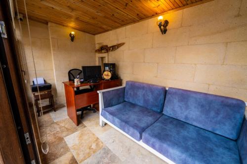 a living room with a blue couch and a desk at Asyada Suites Hotel in Nevsehir