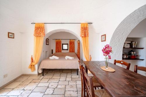 a bedroom with a bed and a table at Villa Trullo Ulivo with pool in Carovigno