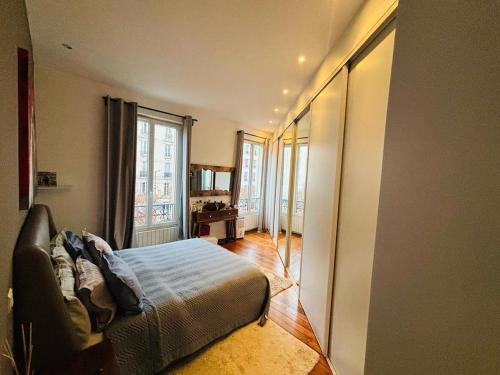 une chambre avec un lit et une grande fenêtre dans l'établissement Appartement NY in Paris with love, à Levallois-Perret
