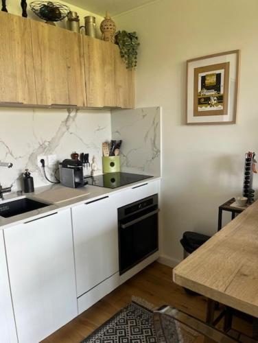 - une cuisine avec des placards blancs, un évier et une table dans l'établissement Chambre chez l'habitant, au pied de la plage, piscine et vue océan, à Bidart