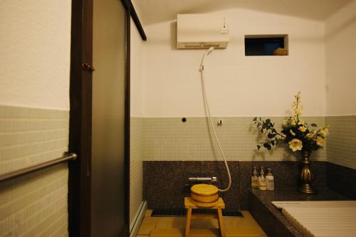 a bathroom with a shower and a toilet and a sink at Rakumankan in Kyoto