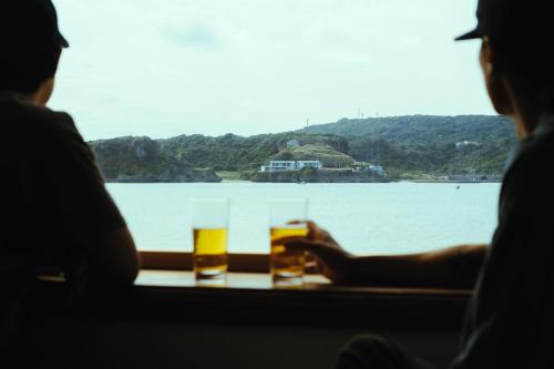 two people sitting at a table with two glasses of beer at ASAHi in Ikei