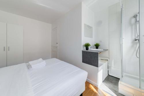 - une chambre blanche avec un lit et une douche dans l'établissement 2 pieces cosy hopital bichat - paris 18 - 2P, à Paris
