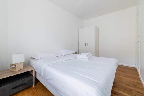 - une chambre blanche avec un lit et une table de nuit dans l'établissement 2 pieces cosy hopital bichat - paris 18 - 2P, à Paris