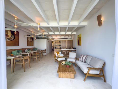a living room with a couch and tables and chairs at Noualt Suites in Ferreries