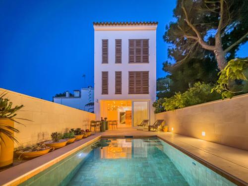 a house with a swimming pool at night at Noualt Suites in Ferreries