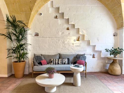 a living room with a couch and a brick wall at Noualt Suites in Ferreries