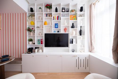 - un salon avec une télévision sur un meuble blanc dans l'établissement CIA - Chic Flat in Marais with AC, à Paris