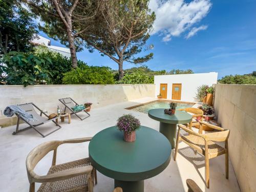 a patio with two tables and chairs and a pool at Noualt Suites in Ferreries