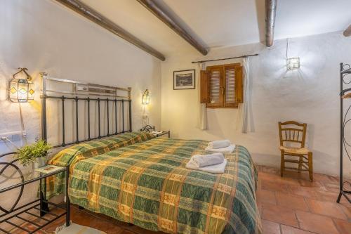 een slaapkamer met een bed met een groene en gele deken bij Casa El Concejo in Cónchar
